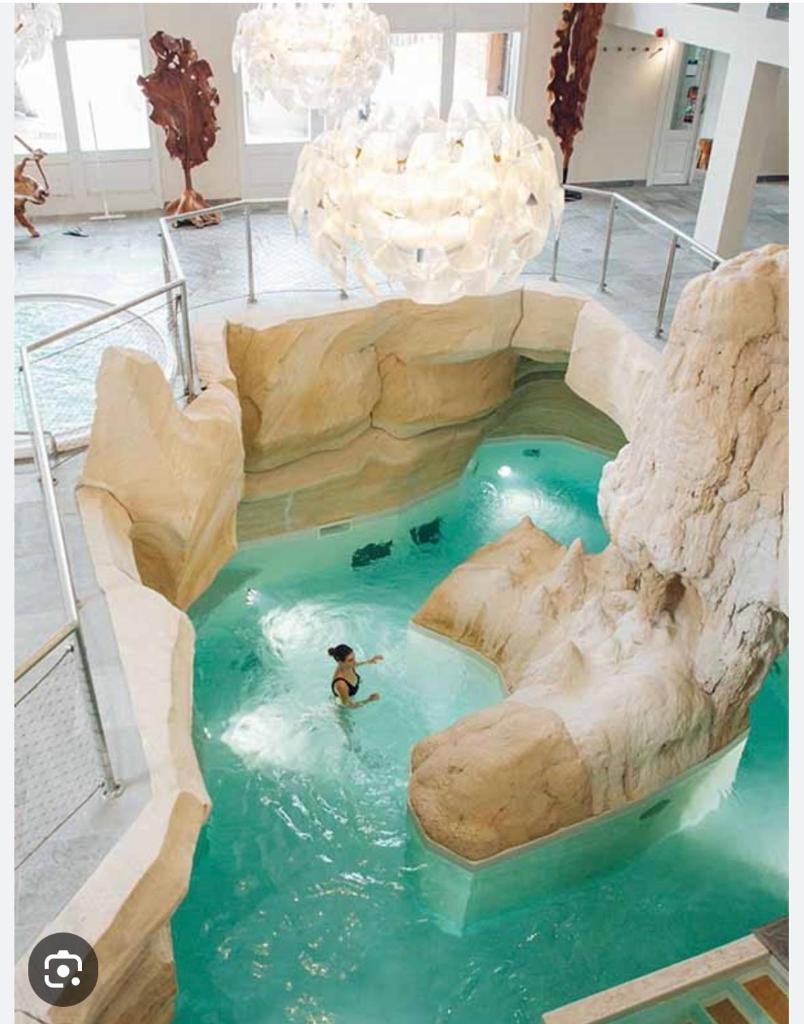 - un homme se baignant dans un toboggan aquatique dans une piscine intérieure dans l'établissement Arc 1950 Ski in Ski out and Spa- Newly refurbished 153 Sources De Marie- 2 bedroom , 2 bathroom-Sleeps 4-6, Mont Blanc view from every window, Free WiFi, à Arc 1950