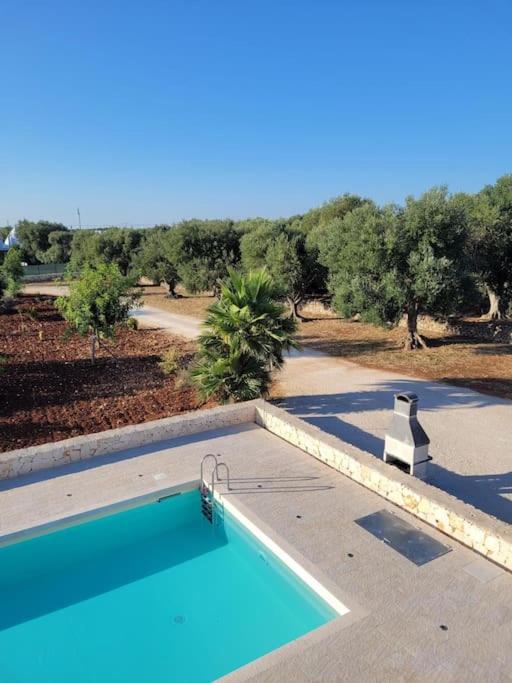 - une piscine avec vue sur une route et des arbres dans l'établissement Villa Dolce Far Niente Ostuni, à Ostuni