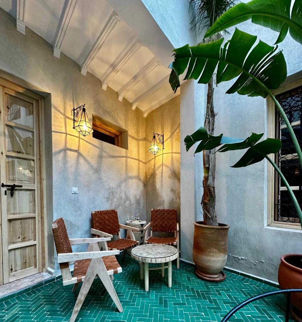une terrasse avec une table, des chaises et une plante dans l'établissement Riad Citrus By La Siredrah, à Marrakech