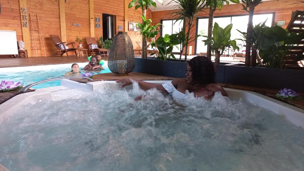 une femme est assise dans un jacuzzi dans l'établissement Les Chalets du Lac Belcaire, à Belcaire