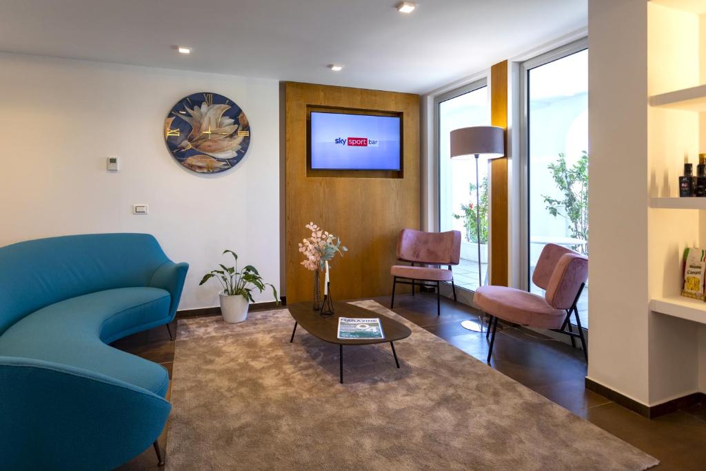 un salon avec un canapé bleu et une table dans l'établissement Park Oasi Resort, à Zambrone