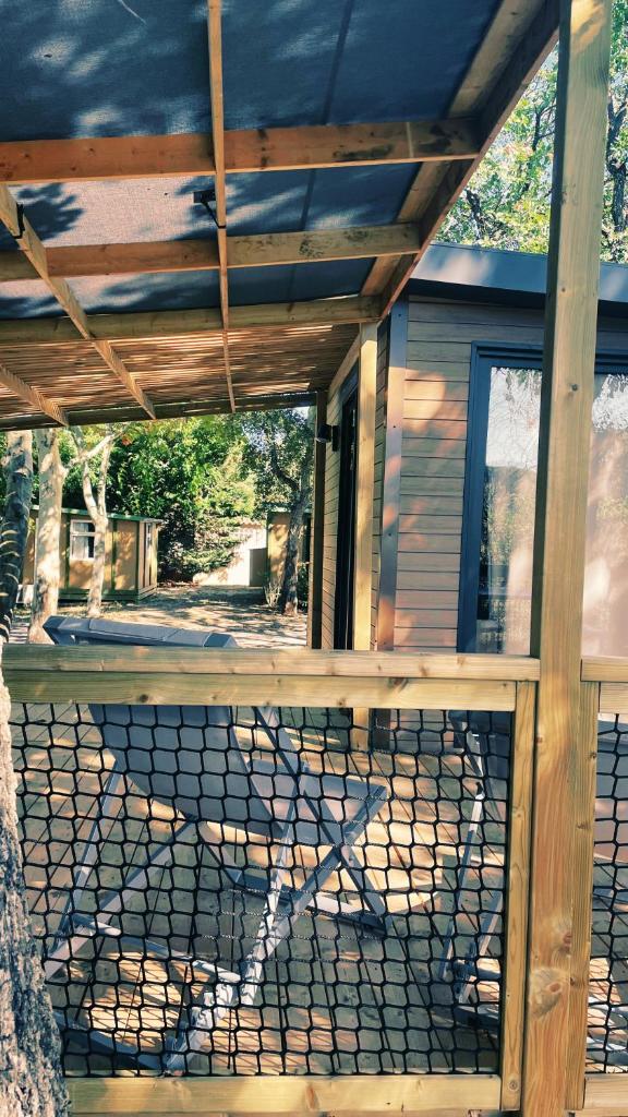 une véranda couverte d'une maison avec une clôture dans l'établissement Camping Sunelia L'Argentière, à Cogolin