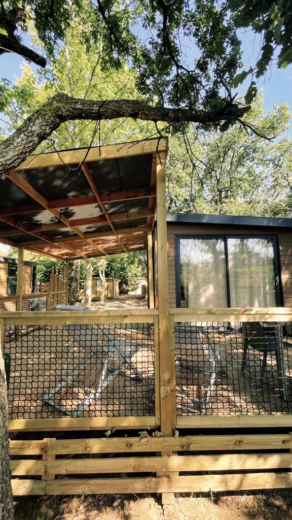 une clôture en bois avec un portail et un arbre dans l'établissement Camping Sunelia L'Argentière, à Cogolin