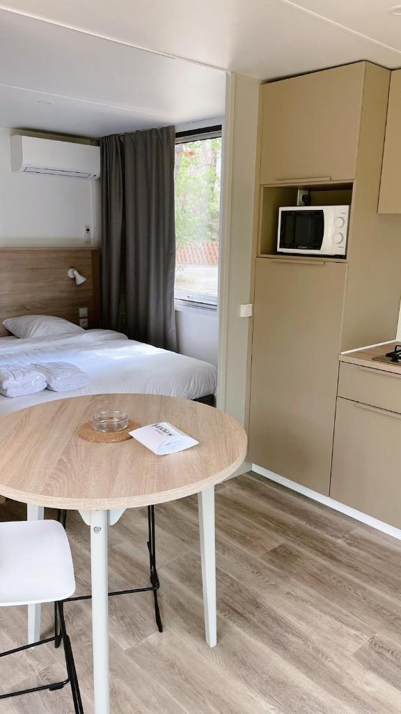 Cette chambre comprend un lit, une table et une cuisine. dans l'établissement Camping Sunelia L'Argentière, à Cogolin 37 autres photos