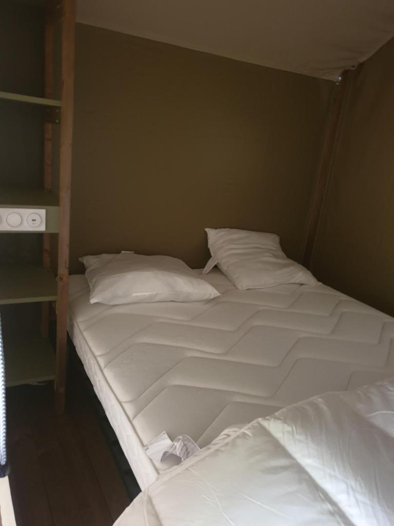 Cette chambre comprend 2 lits avec des draps et des oreillers blancs. dans l'établissement lodge du camping la Porte St Martin, à Saint-Martin-en-Vercors