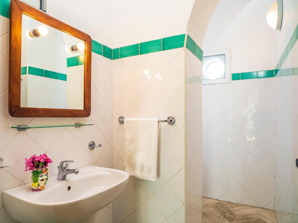 une salle de bain avec un lavabo et un miroir dans l'établissement Hotel Ossidiana Stromboli Center, à Stromboli