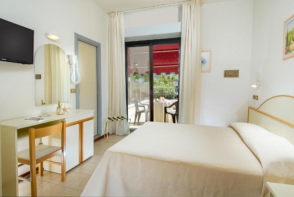 une chambre d'hôtel avec un lit, un bureau et une fenêtre dans l'établissement Hotel Novella, à Misano Adriatico