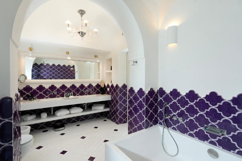- une salle de bains pourpre avec lavabo et miroir dans l'établissement Hotel Miramalfi, à Amalfi