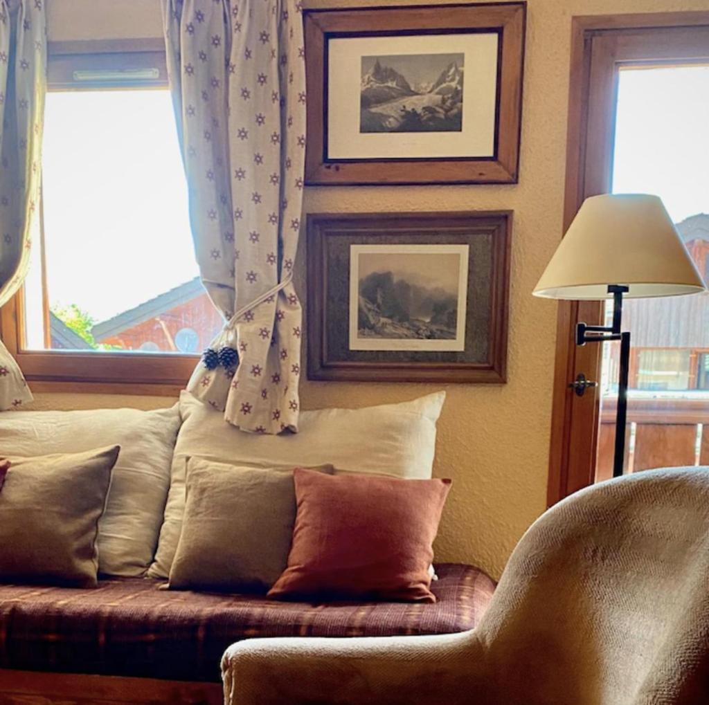 un salon avec un canapé et deux fenêtres dans l'établissement Cosy Apt For 4 In Courchevel, à Courchevel