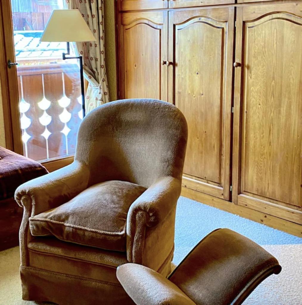 un fauteuil brun dans un salon avec une lampe dans l'établissement Cosy Apt For 4 In Courchevel, à Courchevel