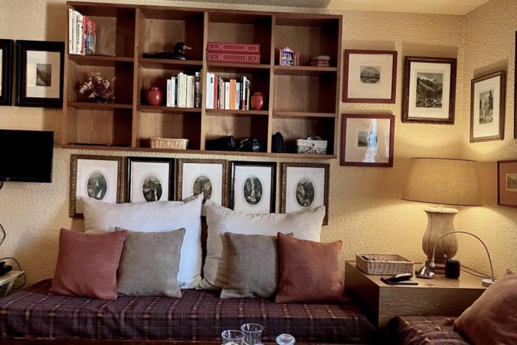 - un salon avec un canapé, des oreillers et une étagère à livres dans l'établissement Cosy Apt For 4 In Courchevel, à Courchevel