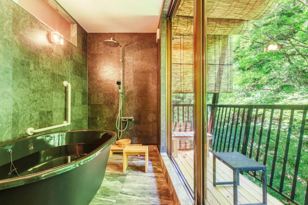 La salle de bains est pourvue d'une baignoire et d'un balcon. dans l'établissement Misenkan, à Tenkawa