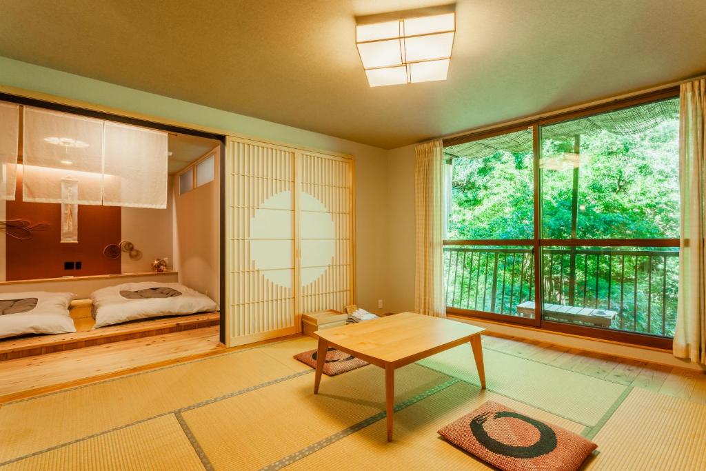 une chambre avec un lit, une table et une fenêtre dans l'établissement Misenkan, à Tenkawa