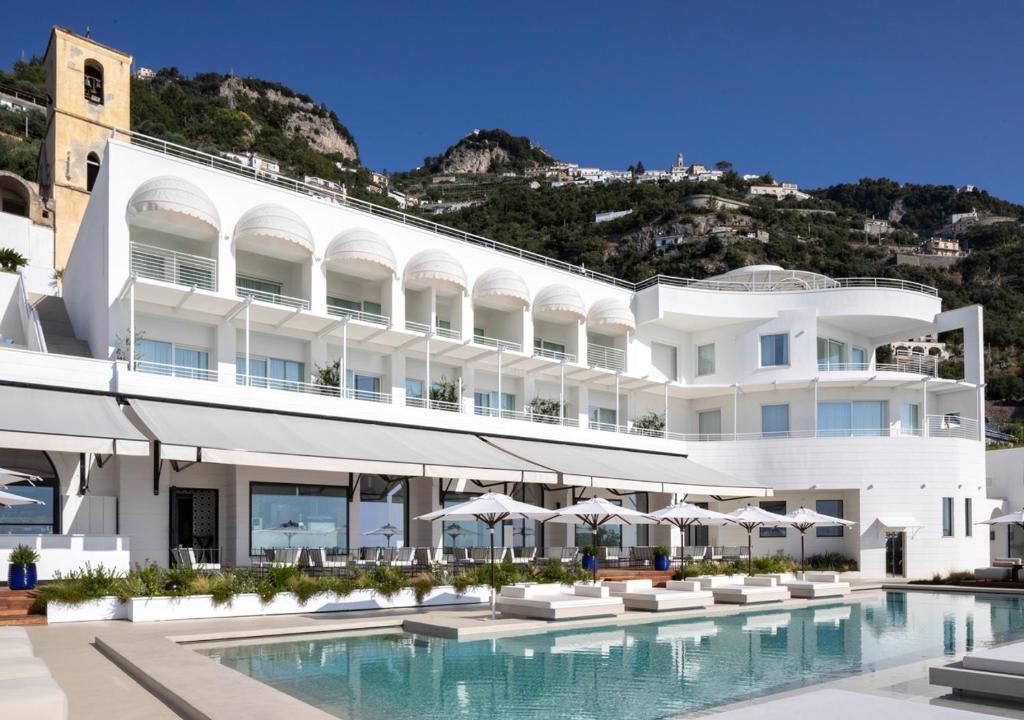 un grand bâtiment blanc avec une piscine dans l'établissement Furore Grand Hotel, à Furore