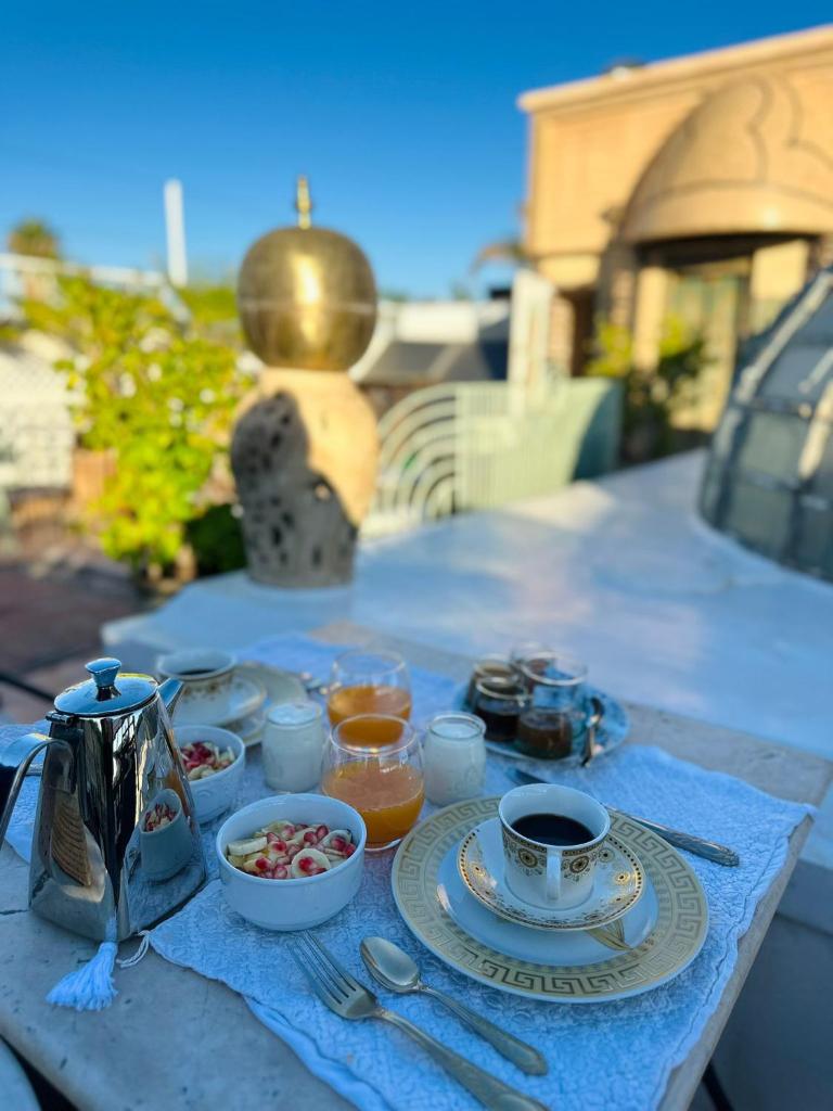 - une table avec des assiettes de nourriture et de boissons dans l'établissement Riad Esmeralda, à Marrakech