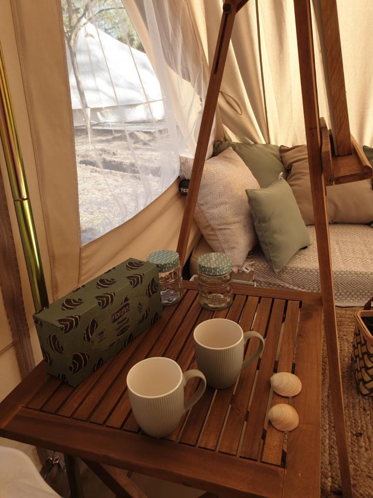 - une table en bois avec deux tasses dans une tente dans l'établissement Le Jeklo, à Vias