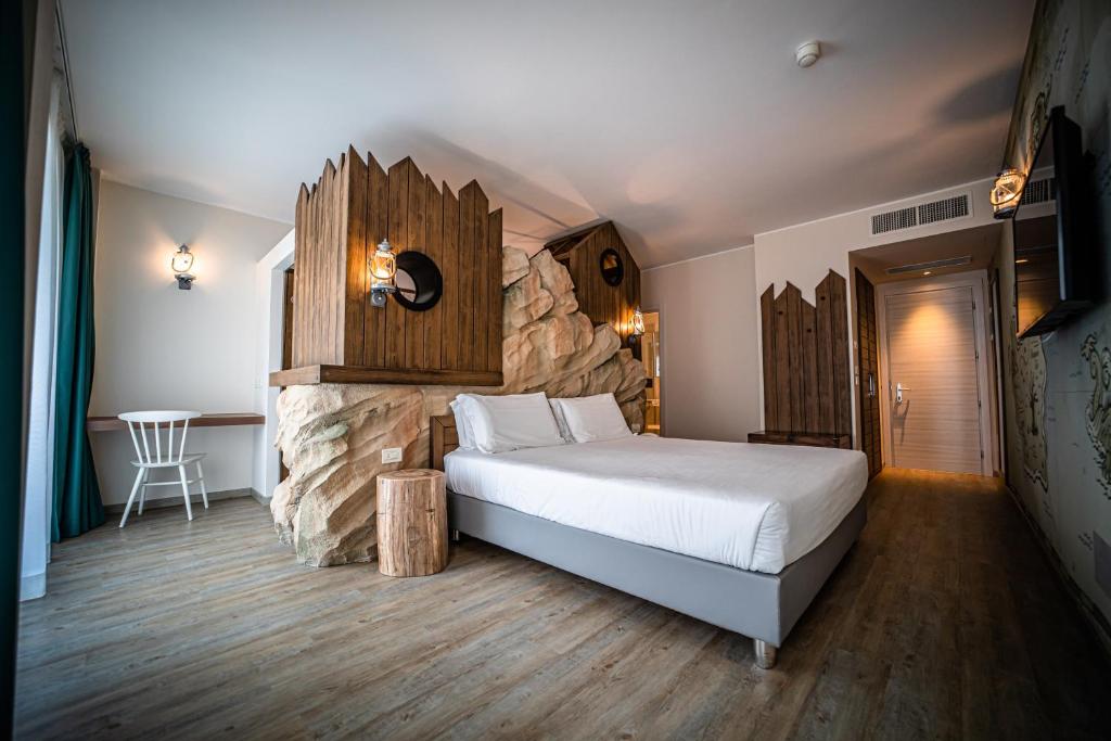 une chambre avec un grand lit et un mur en pierre dans l'établissement Hotel San Michele, à Bibione