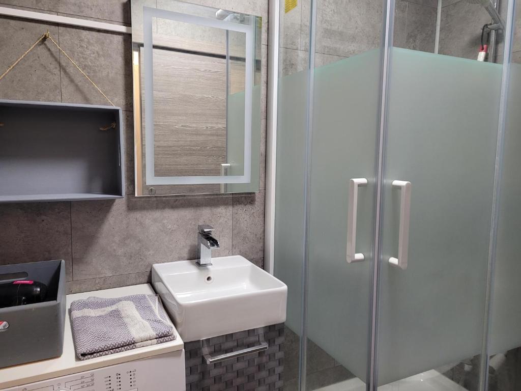 une salle de bain avec un lavabo et une douche en verre dans l'établissement STUDIO plein sud "Les Arolles" Balcon de VILLARD DE LANS, à Villard-de-Lans