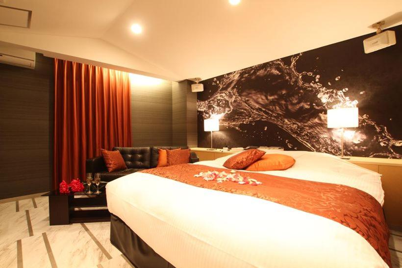 une chambre d'hôtel avec un lit et un canapé dans l'établissement ホテルミュゼ愛子Hotel MUSEE Ayashi, à Sendai