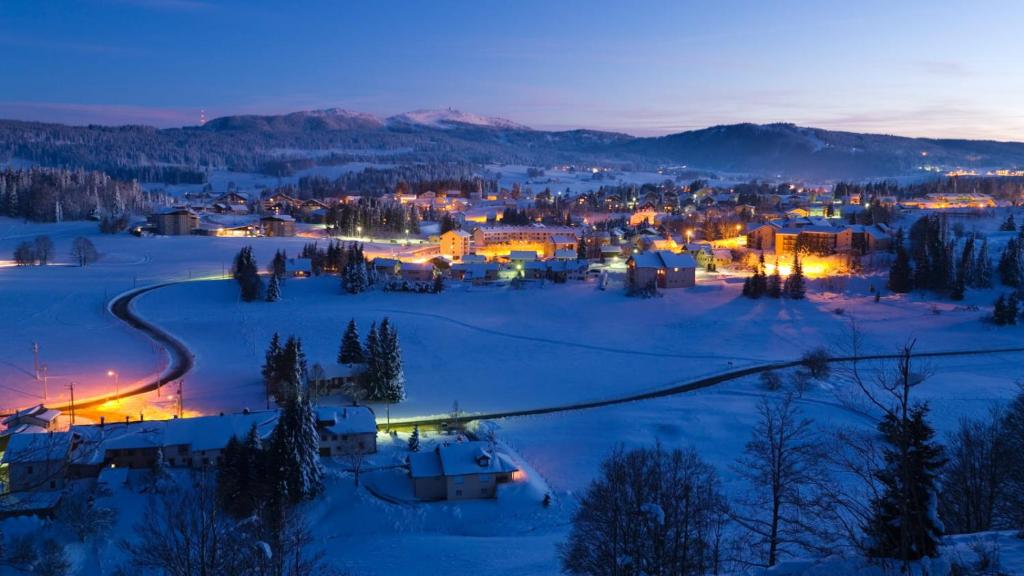 Une petite ville dans la neige la nuit dans l'établissement Grand Studio rénové, tout confort, belles prestations - Résidence du Bois de l'Ours, aux Rousses