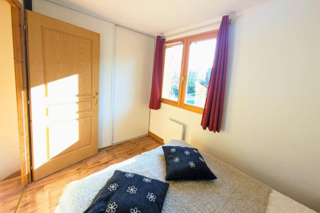 - une chambre avec 2 oreillers sur un lit et une fenêtre dans l'établissement Chalet MÖKI accès piscine sauna, à Les Déserts