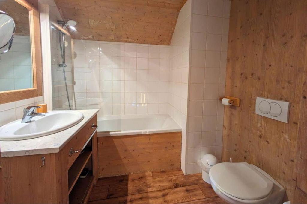 une salle de bain avec un lavabo, une baignoire et des toilettes dans l'établissement Chalet MÖKI accès piscine sauna, à Les Déserts 6 autres photos