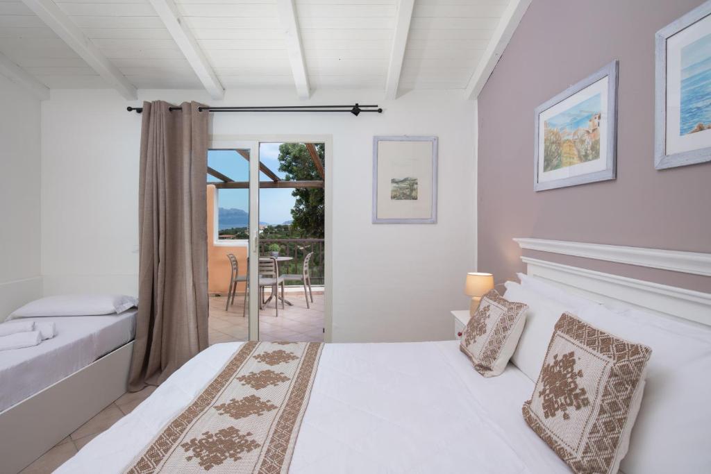 une chambre blanche avec un lit et un balcon dans l'établissement VOI Colonna Village, à Golfo Aranci 44 autres photos