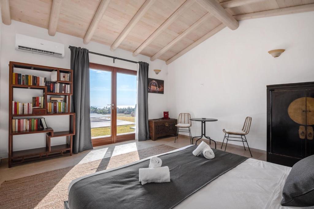 une chambre avec un lit, une table et des chaises dans l'établissement Villa Ella, à Castrignano del Capo
