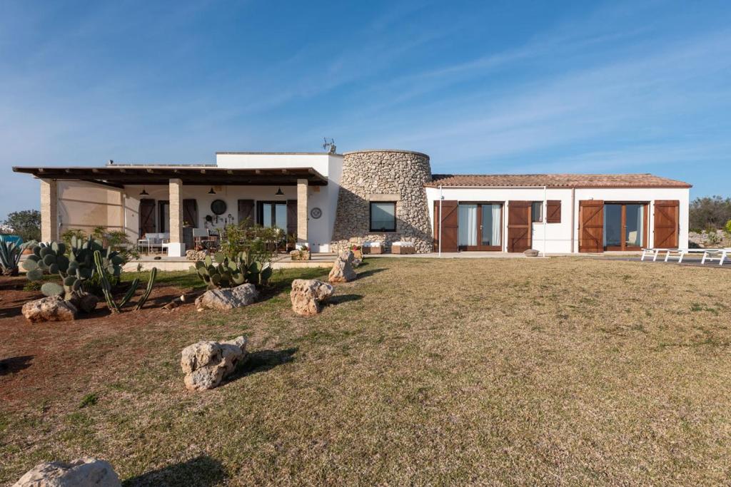 une maison avec une cour avec des rochers devant dans l'établissement Villa Ella, à Castrignano del Capo