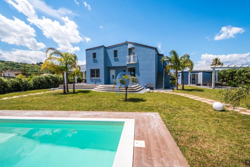 une maison avec une piscine devant une maison dans l'établissement Villa Azzurra con piscina privata, à Lascari