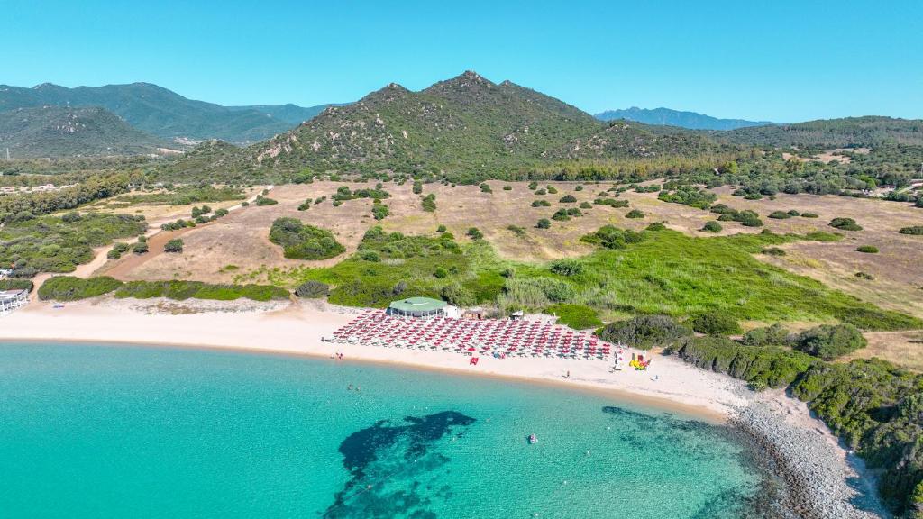 - une vue aérienne sur une plage avec un groupe de tables dans l'établissement Sant'Elmo Beach Hotel, à Castiadas