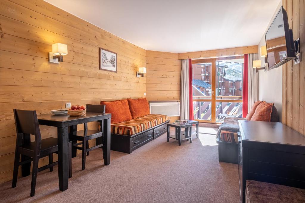 un salon avec un canapé et une table dans l'établissement Résidence Pierre & Vacances Le Tikal, à Val Thorens