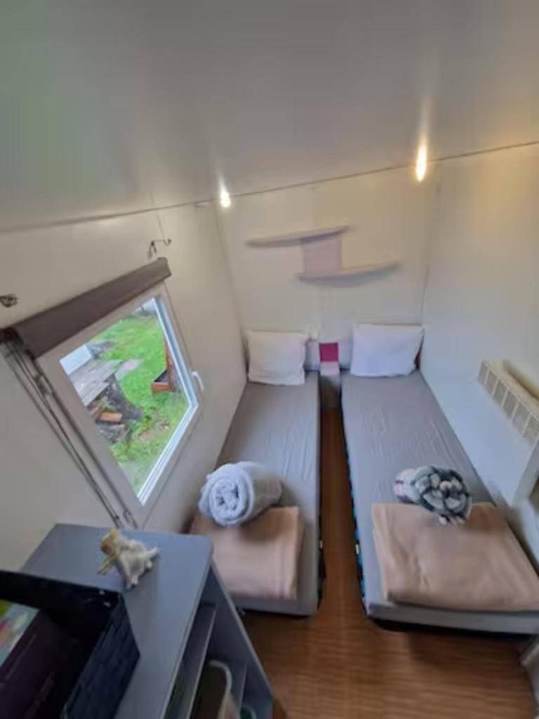 une petite chambre avec deux lits et une fenêtre dans l'établissement Charmant mobilhome à 2 pas remontés ski Samoëns, à Samoëns