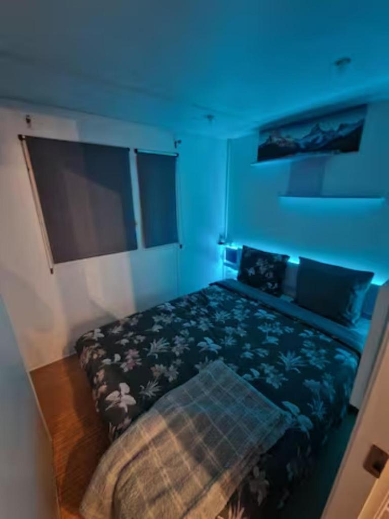 une chambre avec un lit dans une pièce bleue dans l'établissement Charmant mobilhome à 2 pas remontés ski Samoëns, à Samoëns 9 autres photos