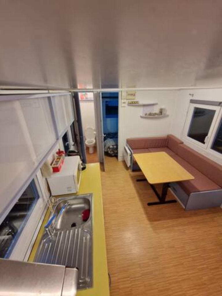 une petite chambre avec un canapé et une table dans une cuisine dans l'établissement Charmant mobilhome à 2 pas remontés ski Samoëns, à Samoëns