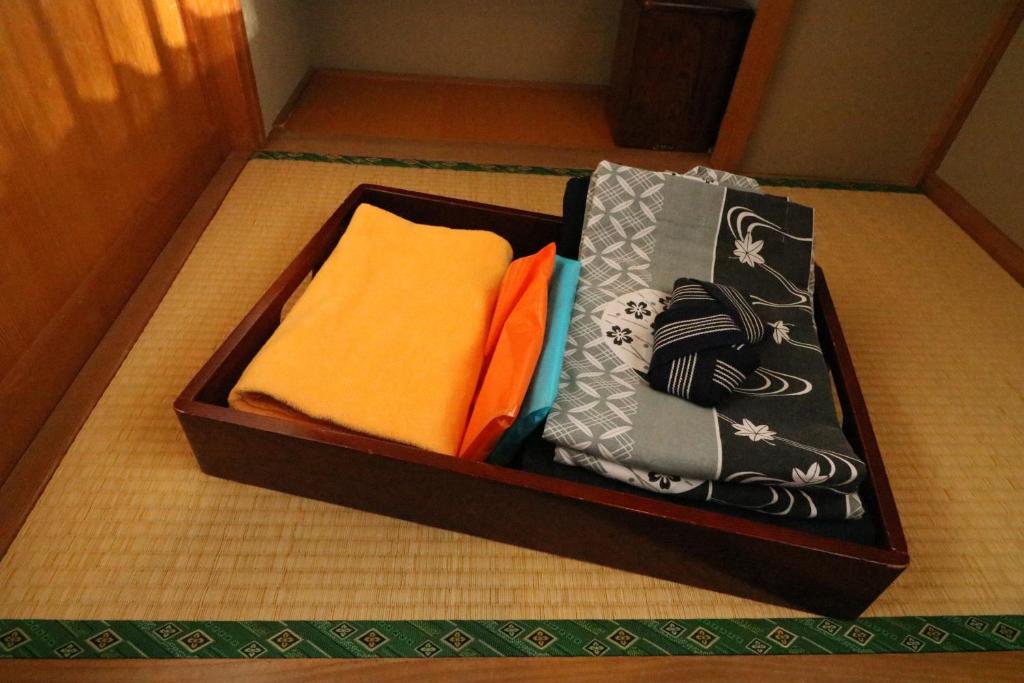 - une boîte en bois remplie de serviettes au sol dans l'établissement Wakamizusou, à Fujikawaguchiko