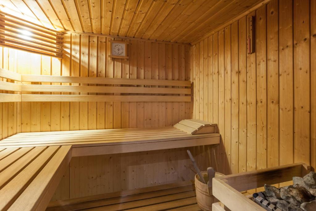 - un sauna en bois avec un banc et une horloge dans l'établissement Résidence Pierre & Vacances Le Thabor, à Valmeinier