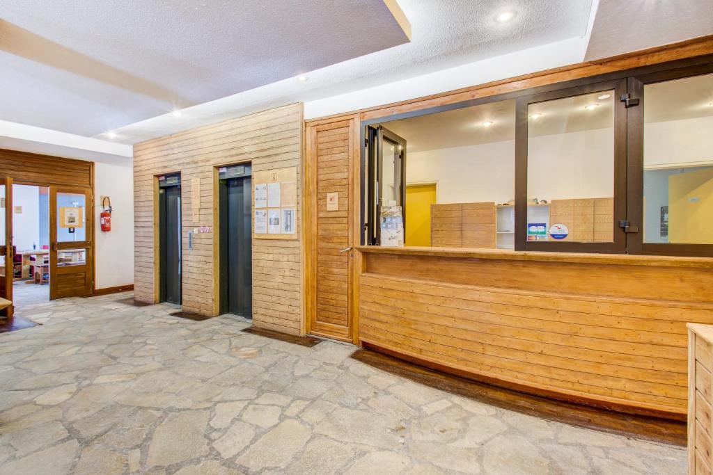 une salle d'attente avec boiseries et fenêtres dans l'établissement Vacancéole - Le Borsat IV, à Tignes