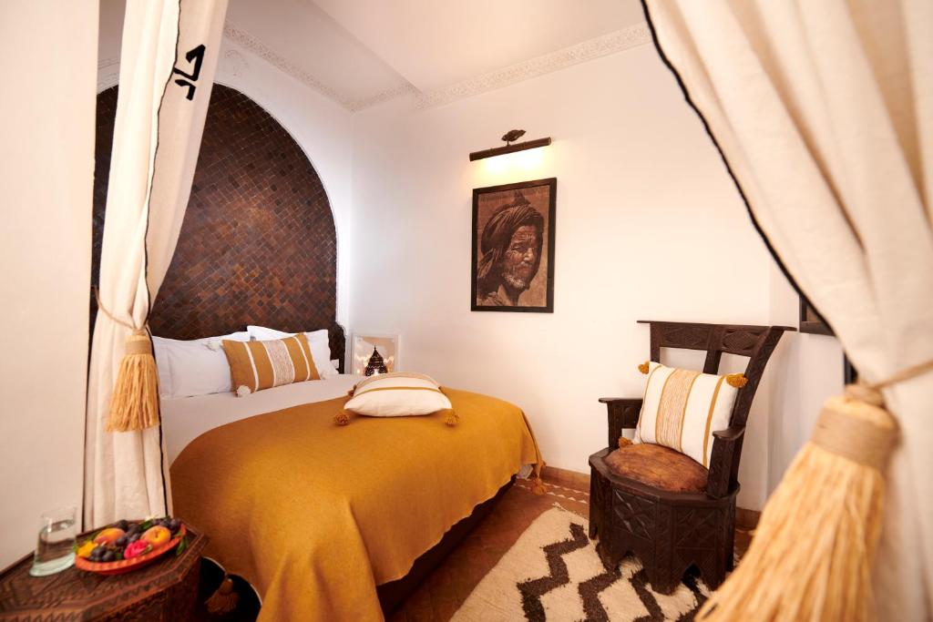 une chambre avec un lit et une chaise dans l'établissement Riad Dar Amanza en exclusivité avec 4 chambres au coeur de la médina, à Marrakech