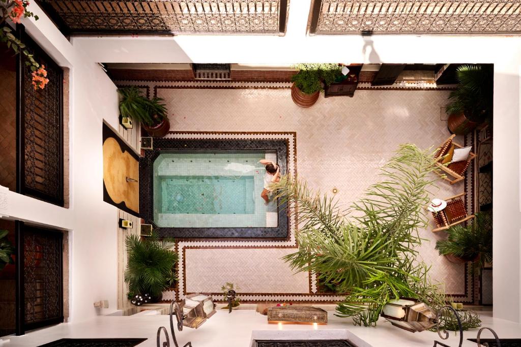 Cette chambre comprend un miroir mural orné de plantes. dans l'établissement Riad Dar Amanza en exclusivité avec 4 chambres au coeur de la médina, à Marrakech