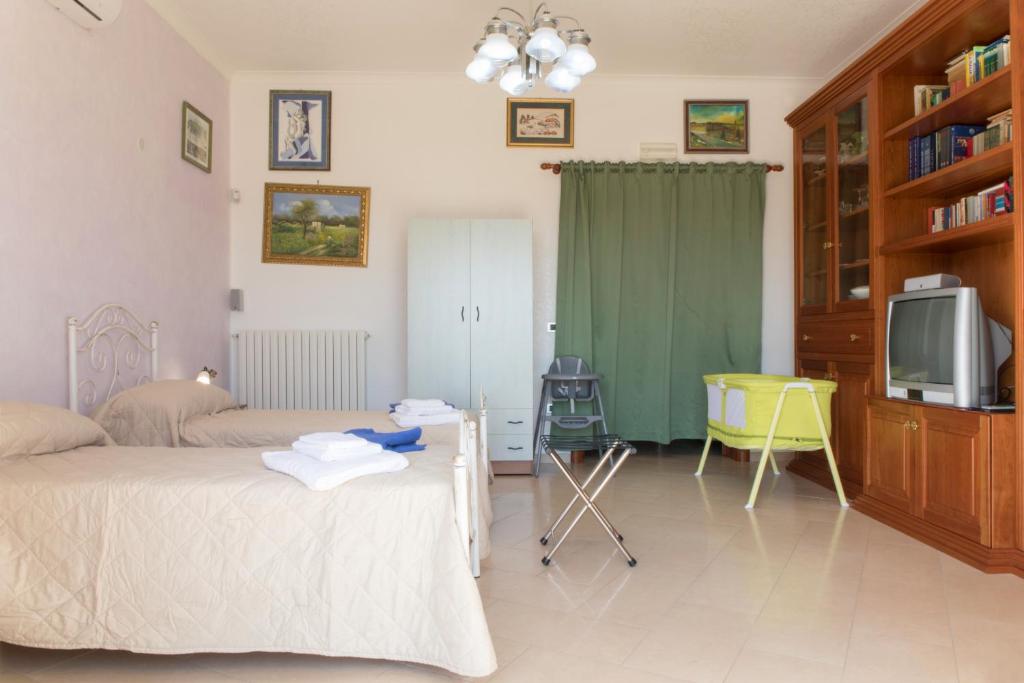 une chambre avec un lit, une télévision et un bureau dans l'établissement Villa Eleonora con piscina Fronte Mare, à Capilungo