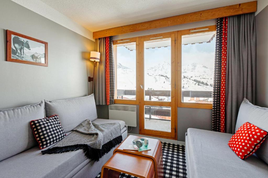 un salon avec un canapé et une fenêtre dans l'établissement Résidence Pierre & Vacances Les Constellations, à Belle Plagne 29 autres photos