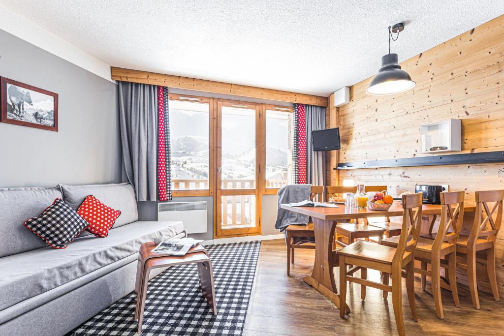 un salon avec un canapé et une table dans l'établissement Résidence Pierre & Vacances Les Constellations, à Belle Plagne