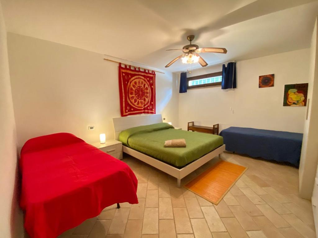 une chambre avec un lit vert et une couverture rouge dans l'établissement Villa Toscagialla, à San Vincenzo
