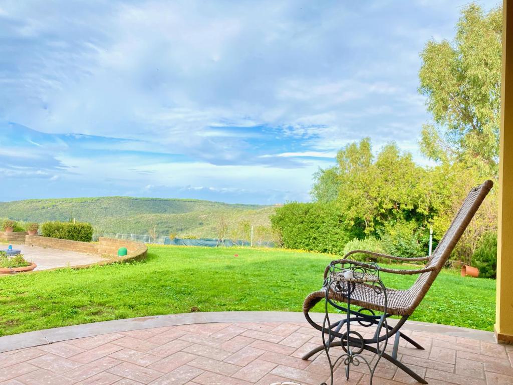 un banc assis sur une terrasse donnant sur un parc dans l'établissement Villa Toscagialla, à San Vincenzo