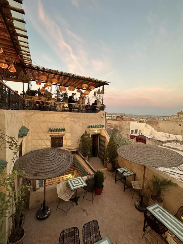 un patio extérieur avec des tables et des chaises dans un bâtiment dans l'établissement Dar Rafti, à Fès
