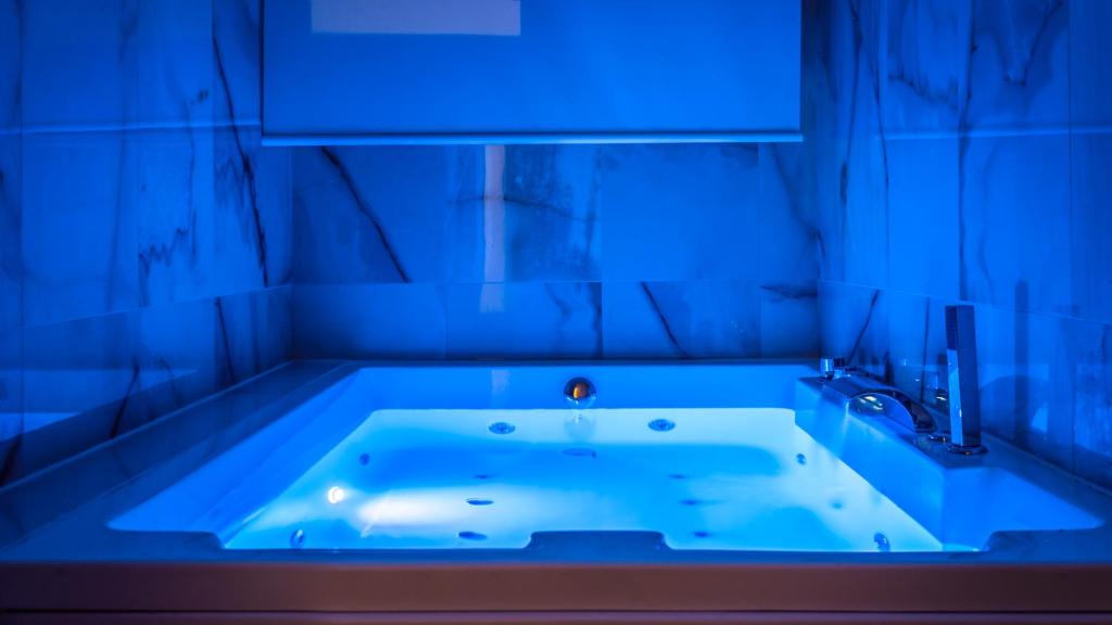 La salle de bains est pourvue d'une baignoire avec une lumière bleue. dans l'établissement La Gigasuite - Design Villa at Sea with Spa & Pool, à Tarente 99 autres photos