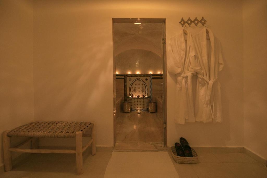 Cette chambre dispose d'une cheminée avec un banc et une chaise. dans l'établissement Riad l'Esprit des Patios & Spa, à Marrakech