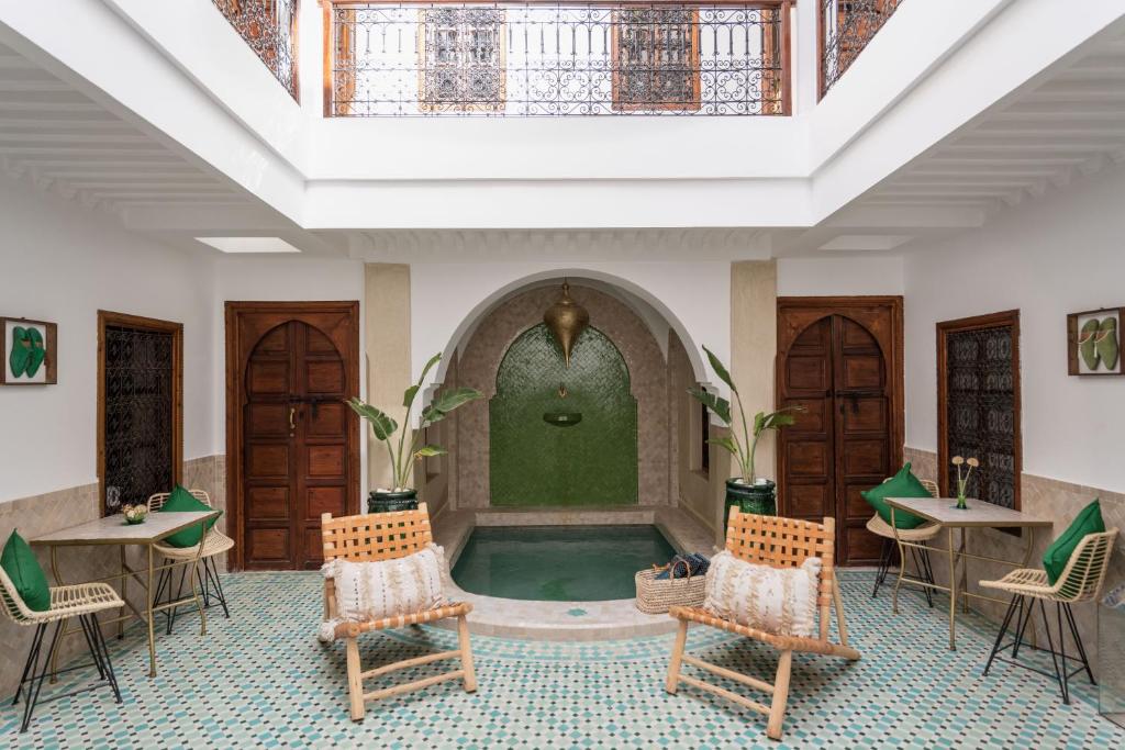 - une piscine dans une pièce avec des chaises et une fontaine dans l'établissement Riad of the Moon, à Marrakech