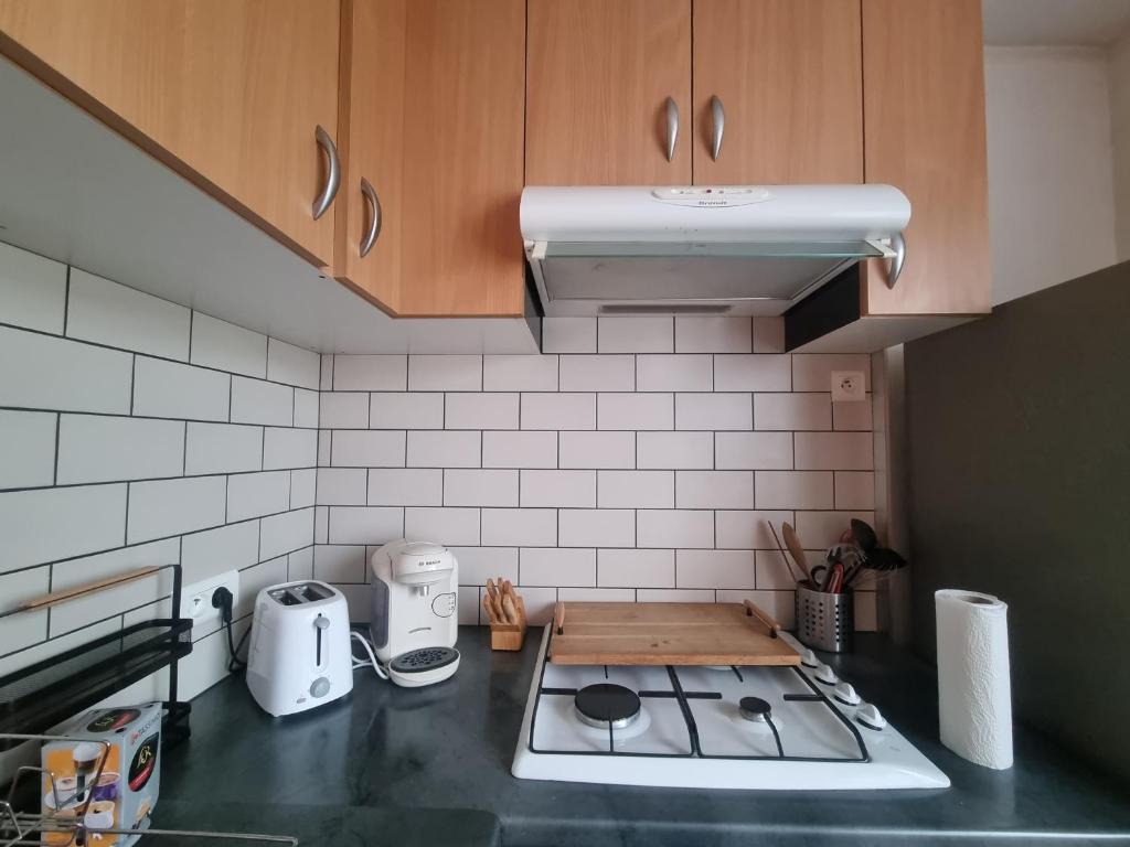 une cuisine avec un comptoir avec une cuisinière dans l'établissement Appartement Aurillacois, à Aurillac